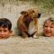 The Prince of Wales and the Princess Royal buried in the sand